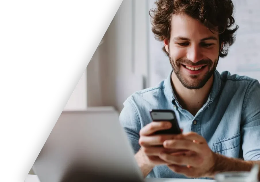 man achter computer met mobiel